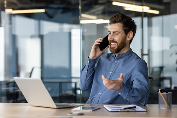 Professional man smiling while using smartphone at office desk