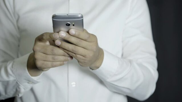 man wearing a white shirt, checking news on cell phone, and getting angry while reading, stressed, constricted man