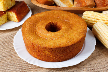 corn cake on white plate on rustic wooden table. Typical Brazilian party food.