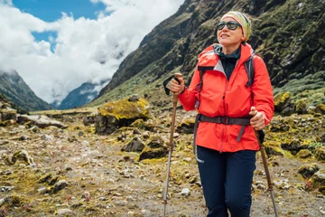 Papier Peint photo autocollant Makalu Portrait of Woman in sunglasses with backpack and trekking poles dressed red softshell jacket hiking on Makalu Barun National Park trek in Nepal. Mountain hiking, traveling and active people concept
