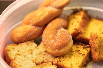 Pedaços de bolo e pão doce ( Rosca doce - como é conhecido no Brasil ) dentro de um recipiente...