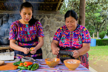 Two women from the Mayan ethnic group prepare the food in an artisanal way.