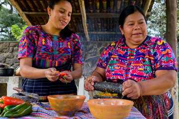 Mayan woman grinds the vegetables using two polished artisanal stones to fulfill the purpose.
