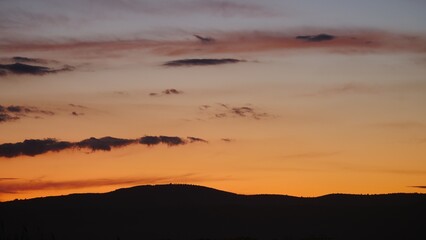 Sunset over hilly coastal land