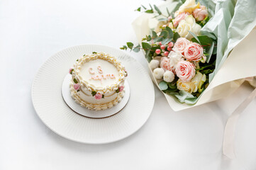 Festive bento cake and bouquet on a light background