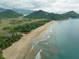 Waves crash against the long and empty shoreline