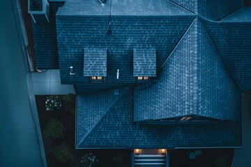 A bird's-eye perspective capturing the depth of a dramatic craftsman home facade adorned with midnight blue tones, under the moonlit sky.