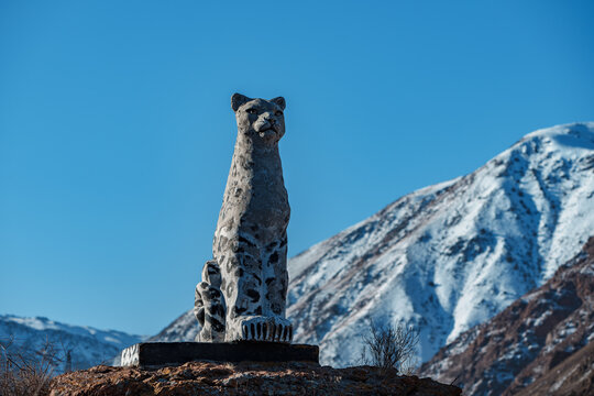 Kyrgyzstan, Central Asia - January 16, 2023: Snow leopard statue on mountain background in winter