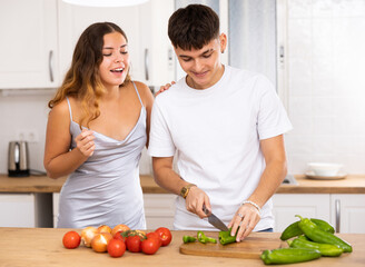 Obraz na płótnie Canvas Young happy married couple cooks breakfast in the kitchen in the morning