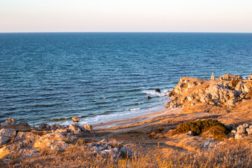 Seascape. Rocky Crimean seashore with sandy beach in the evening. Travel and tourism