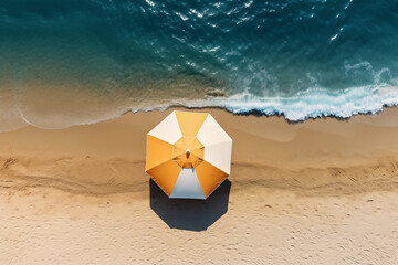 Aerial view of a striped white and yellow beach umbrella in the sand at the beach 