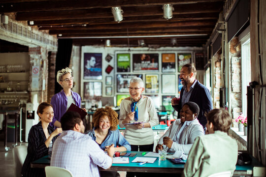 Team meeting with diverse group of professionals discussing project in a modern office