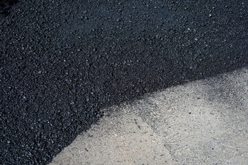Closeup detail of the transition between old and new asphalt on a road construction project

