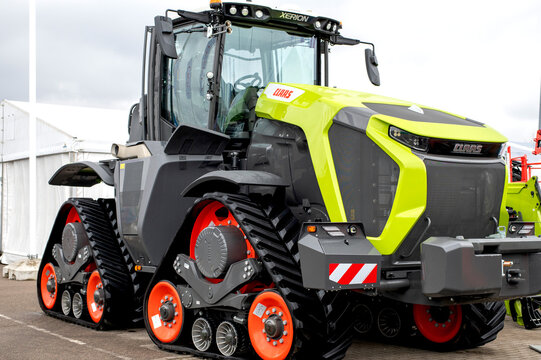Kaunas, Lithuania - March 23, 2024: a yellow and black claas xerion huge tractor with orange tracks is parked in a field.
