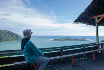 A woman enjoys the view of the coast and islands from the top of the mountains