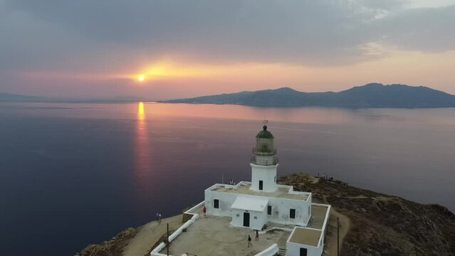 Aerial video of the Armenianstis lighthouse on the seashore at a spectacular sunset in Mykonos