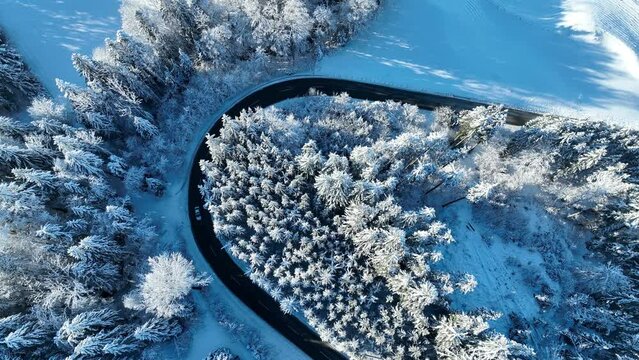 Drohnenvideo von einer scharfen Kurve im Winter mit Straßenverkehr