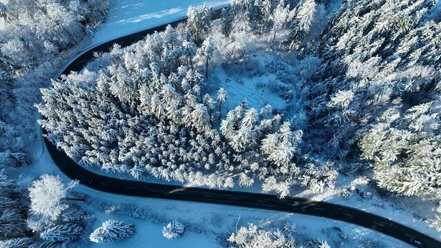 Drohnenvideo von einer scharfen Kurve im Winter mit Straßenverkehr