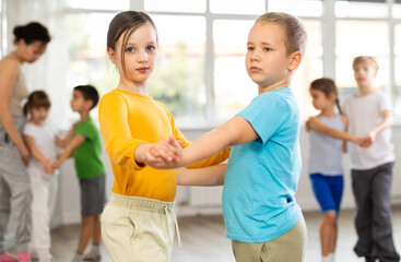 Couple boy and girl rehearsing pair waltz dance in studio