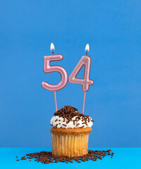 Birthday candle with cupcake on blue background - Number 54