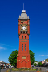 A tall red brick clock tower built in 1896 on a bright clear day in downtown Camperdown, Victoria, Australia.