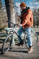 Casual man enjoys a relaxing day at the park with his bike, embodying a hipster lifestyle.