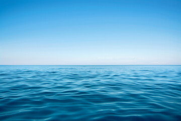Calm sea with endless ocean and its horizon separating the sky from the blue waterand copy space