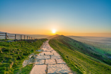 Stone footpath and wooden fence leading a long The Great Ridge in the English Peak District - 779283360