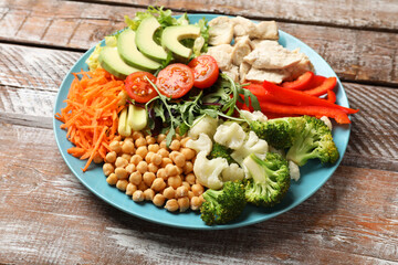 Balanced diet and healthy foods. Plate with different delicious products on wooden table