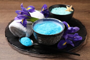 Obraz na płótnie Canvas Light blue sea salt in bowls, flowers, towel and spoon on wooden table