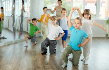 Positive preteen children learning to dance waltz in pairs in choreography class