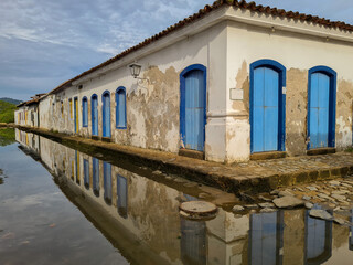Old colonial-style houses reflected in the water at high tide