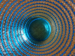 Motivo geometrico cerchi concentrici e superficie vetrosa blu e azzurra trasparente brillante e colorata