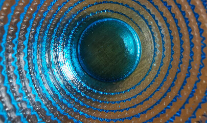 Motivo geometrico cerchi concentrici e superficie vetrosa blu e azzurra trasparente brillante e colorata