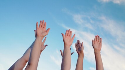 Individuals raise hands toward blue sky as sign of unity. Business collective decision making of people. People put hands up one by one. Hands are raised sequentially collective hand gestures teamwork - Powered by Adobe