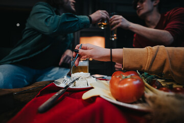 A close-knit scene of friends sharing a meal at home, highlighting a cheese platter and intimate...