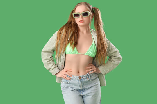 Fototapeta Beautiful young woman in stylish outfit on green background