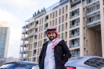 In the backdrop of a sleek, modern urban landscape, a young Arabic businessman stands confidently,...