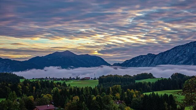 Mist and moody clouds move over Alps in Austria during sunrise timelapse