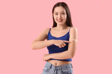 Gordijnen Young woman pointing at applied medical patch on her arm against color background © Pixel-Shot