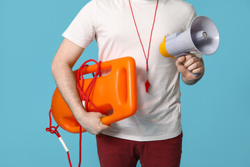 Male lifeguard with rescue tube buoy and megaphone on blue background