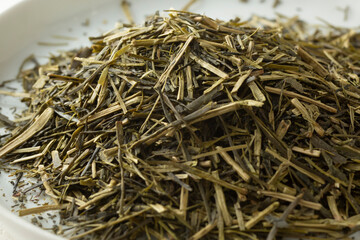 A closeup view of a pile of loose leaf green kukicha green tea. 