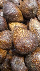 Close up of a pile of snake fruit being sold at the market in the background.	
