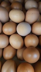 Close up of randomly stacked chicken eggs sold at the market as a background.	
