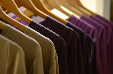 Fototapeta premium Muslimah dresses new collection of stylish clothes wear hanging on hangers clothing rack rails, fabric samples at background. Fashion design studio store concept.