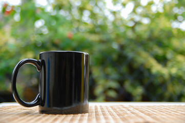 Black mug isolated on a blur background. Morning breakfast concept. The beginning of the day.