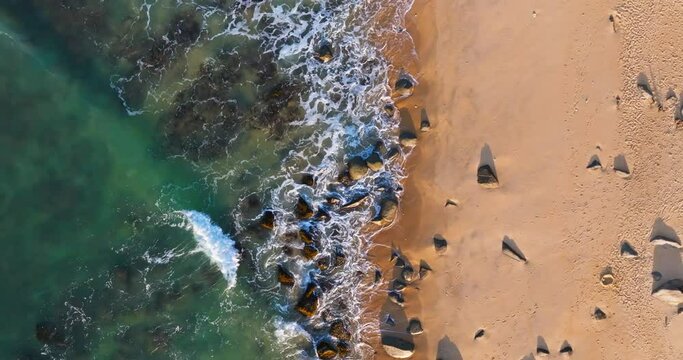 aerial top view of waves crashing on the beach in the morning sunlight in Wanning Hainan China