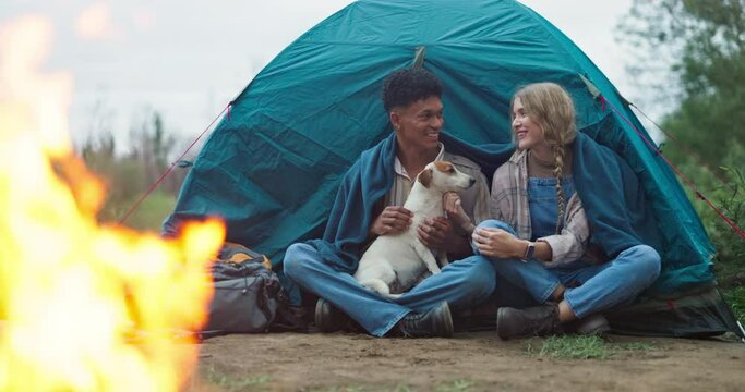 Fire, love and couple camping with dog in forest for travel, adventure or bonding in nature together. Sustainable living, flame and off grid people with pet in jungle for backpacking, fun or journey