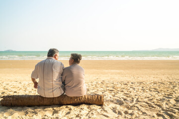 Fototapeta premium Happy Asian family senior couple travel nature ocean on summer beach holiday vacation. Healthy elderly retired people enjoy outdoor lifestyle relaxing together at tropical island beach in sunny day.
