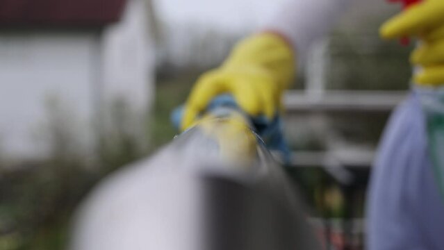 Close up of female hand using wet wipe and hand sanitizer spray to clean stainless steel staircase railing.Antiseptic,disinfection ,cleanliness and heathcare, anti virus concept